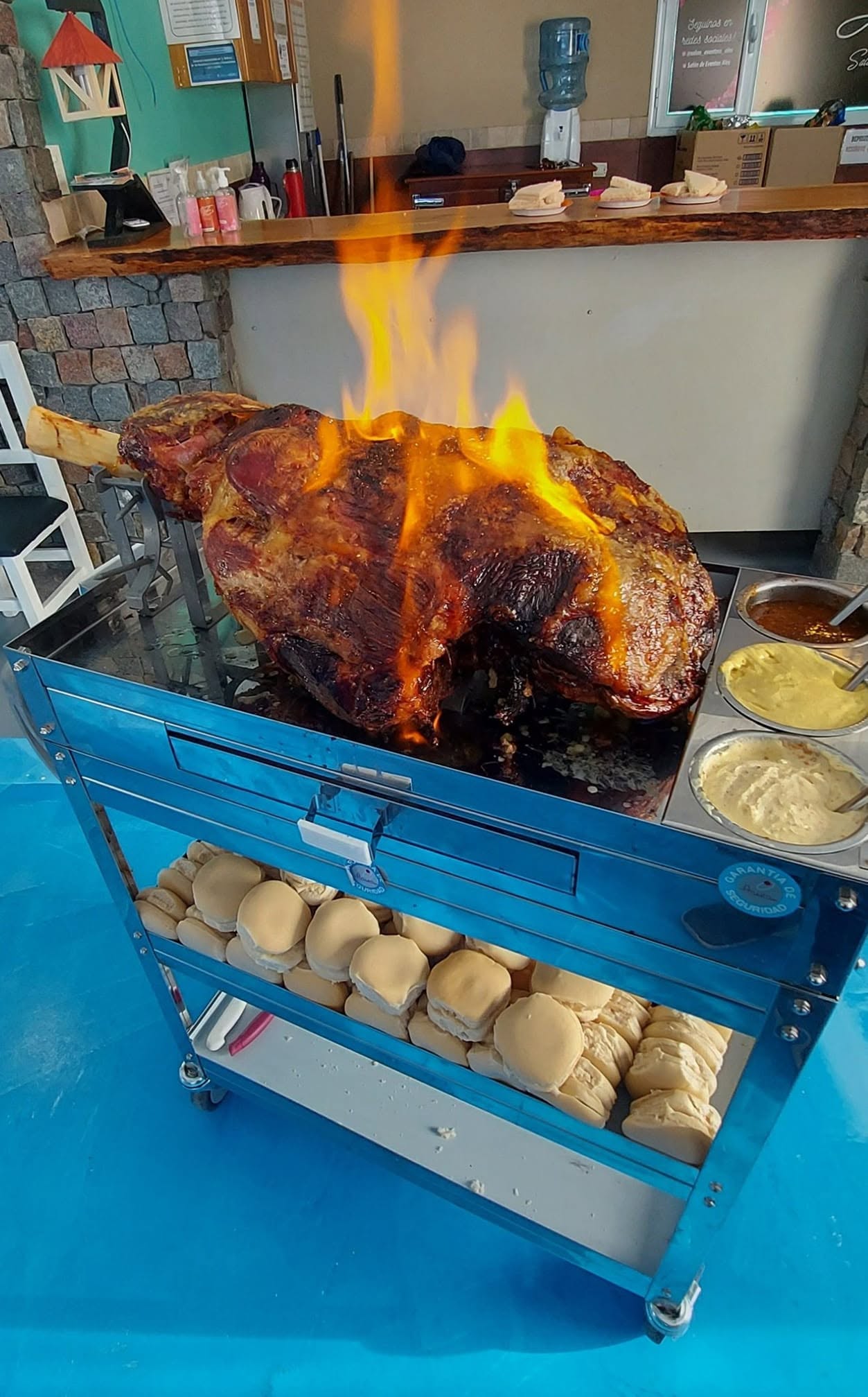 Carrito de pernil flambeado con salsas y panes